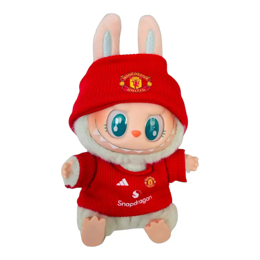 Labubu plush toy wearing the complete Manchester United Football Club jersey outfit, featuring a classic red replica jersey and a coordinating themed hat.