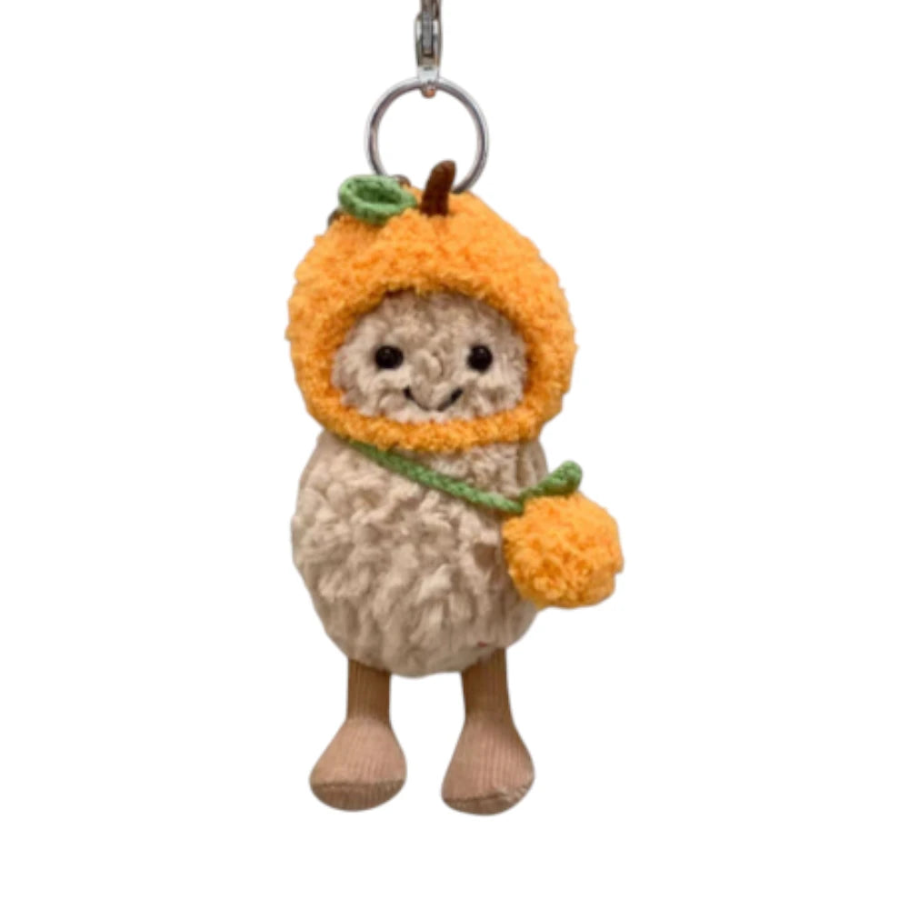 Jellycat Amuseables Peanut keychain wearing an orange-themed head cover and holding a matching small bag.