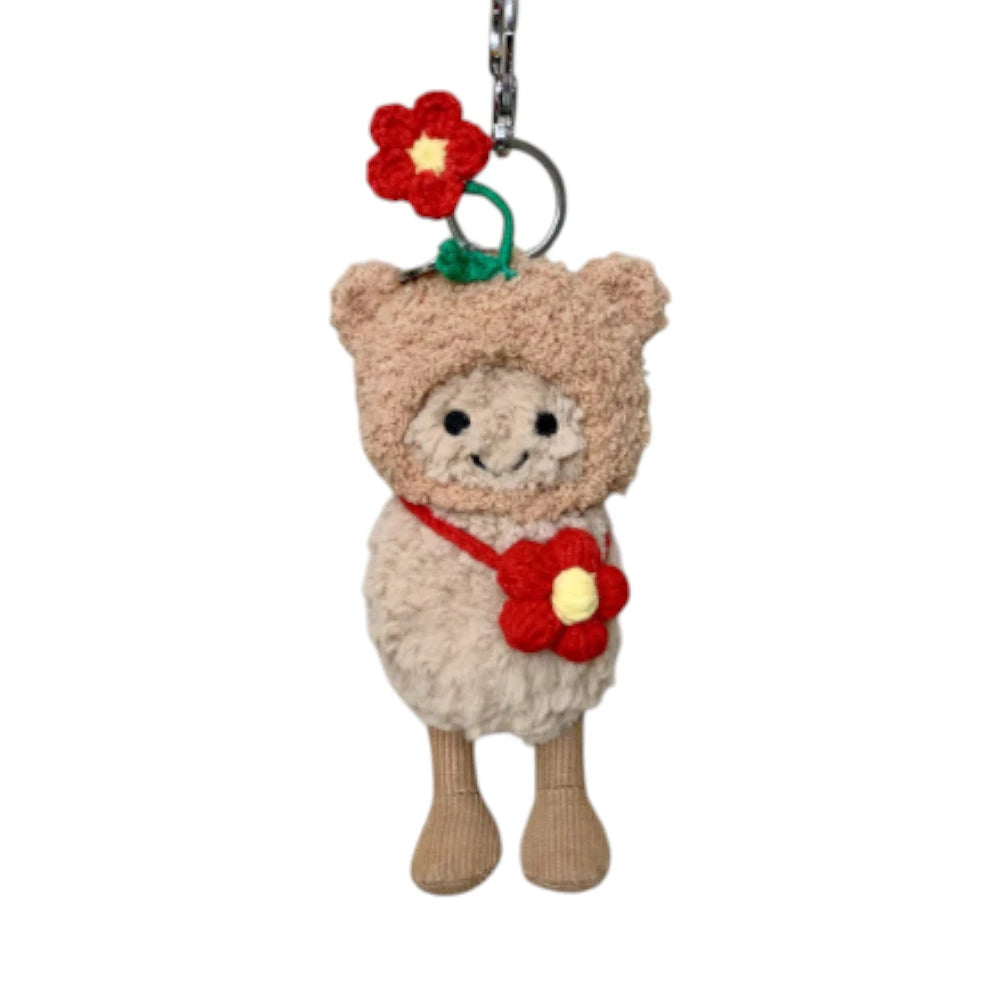 Jellycat Amuseables Peanut keychain wearing a red flower-themed head cover and holding a matching small bag.