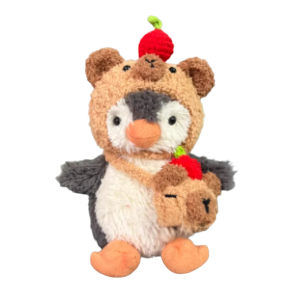 Jellycat Peanut Penguin Bag Charm wearing a capybara-themed head cover and holding a matching small bag.