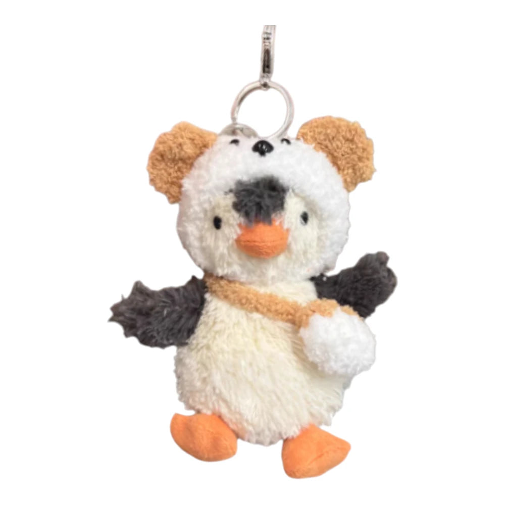 Jellycat Peanut Penguin Bag Charm wearing a dog-themed head cover and holding a matching small bag.