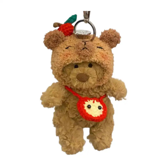 Jellycat Bartholomew Bear Bag Charm wearing a Capybara headcover and holding a small matching bag.