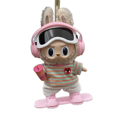 Labubu plush toy wearing a full 6-item Snowboard Outfit, including headphones, snowboard shoes, t-shirt, pants, ski goggles, and a water cup, available in Light Pink and Gradient.